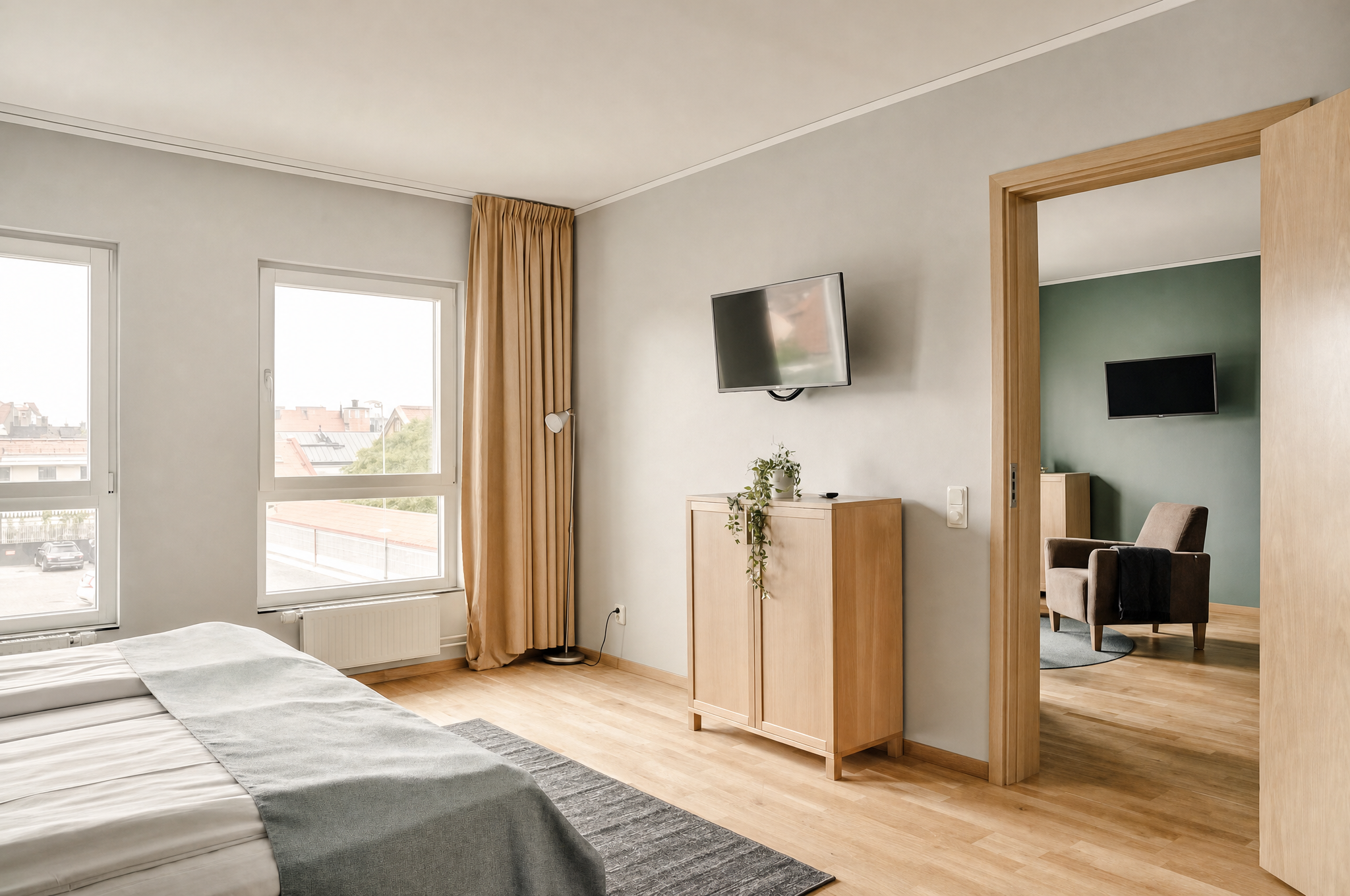 Bedroom with large windows, TV and view into adjoining room