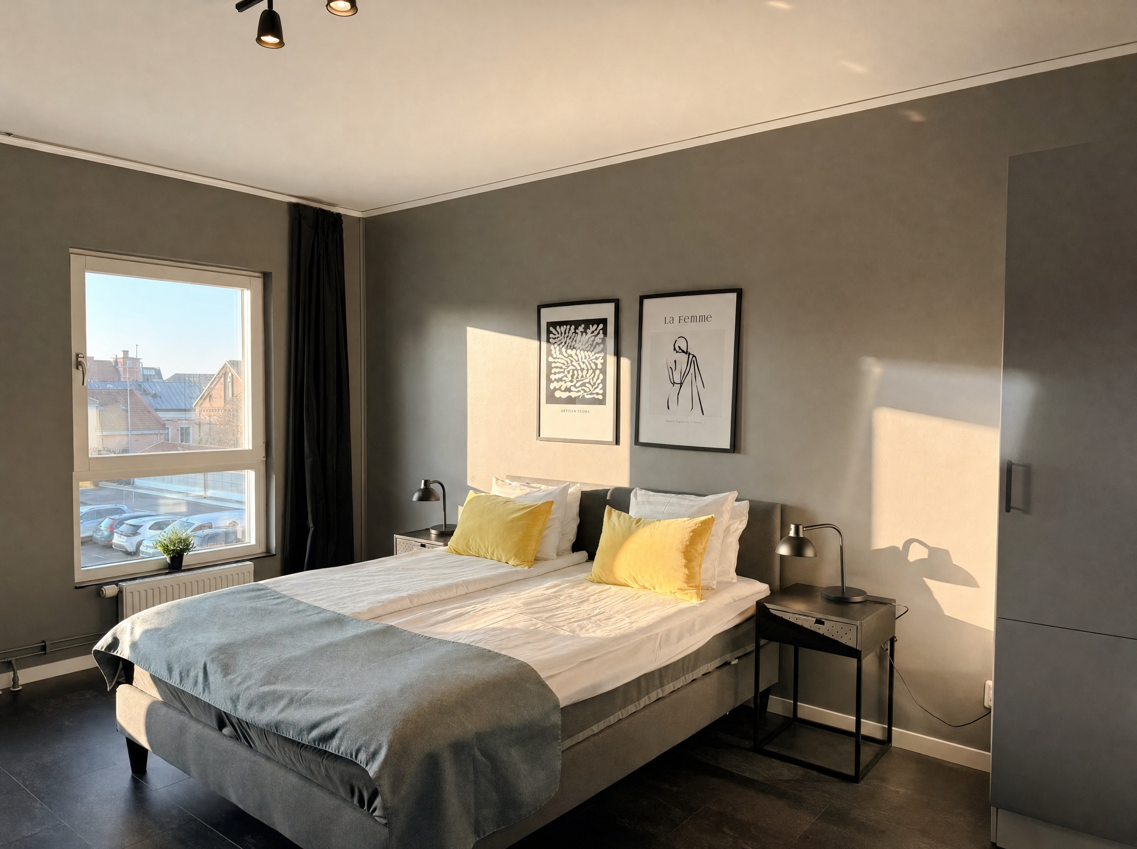 Bedroom with double bed, framed art and city view
