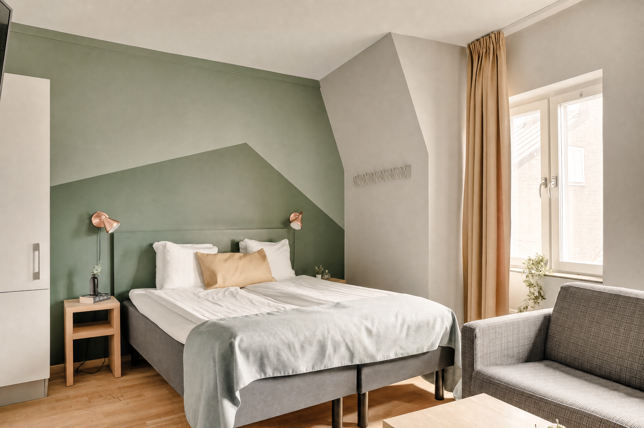 The Nooq Lund — bedroom with sage green walls and natural light